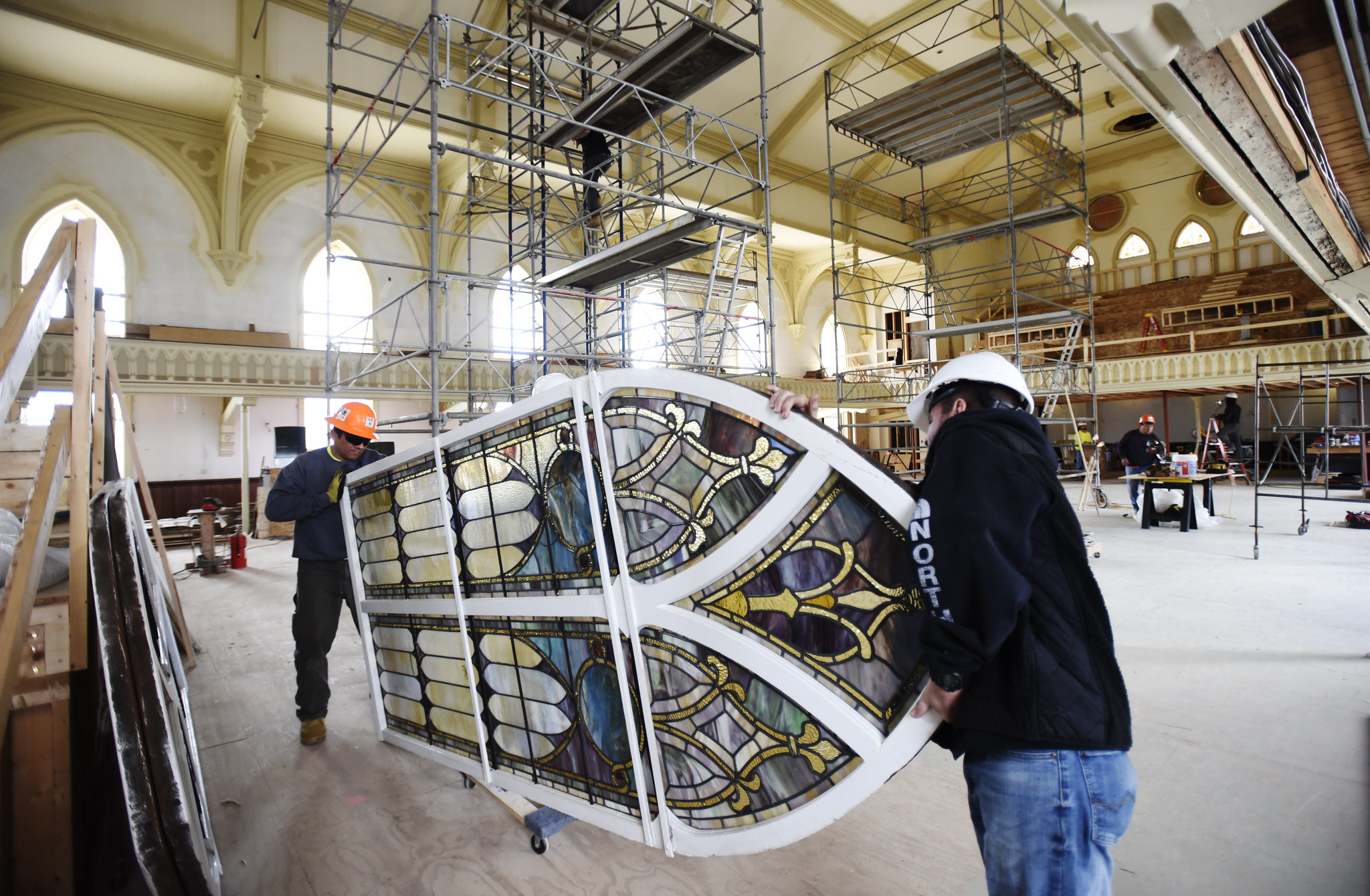 Crews install restored stained glass windows to their homes in the great hall at UPH in Saratoga Tuesday, June 4, 2019.